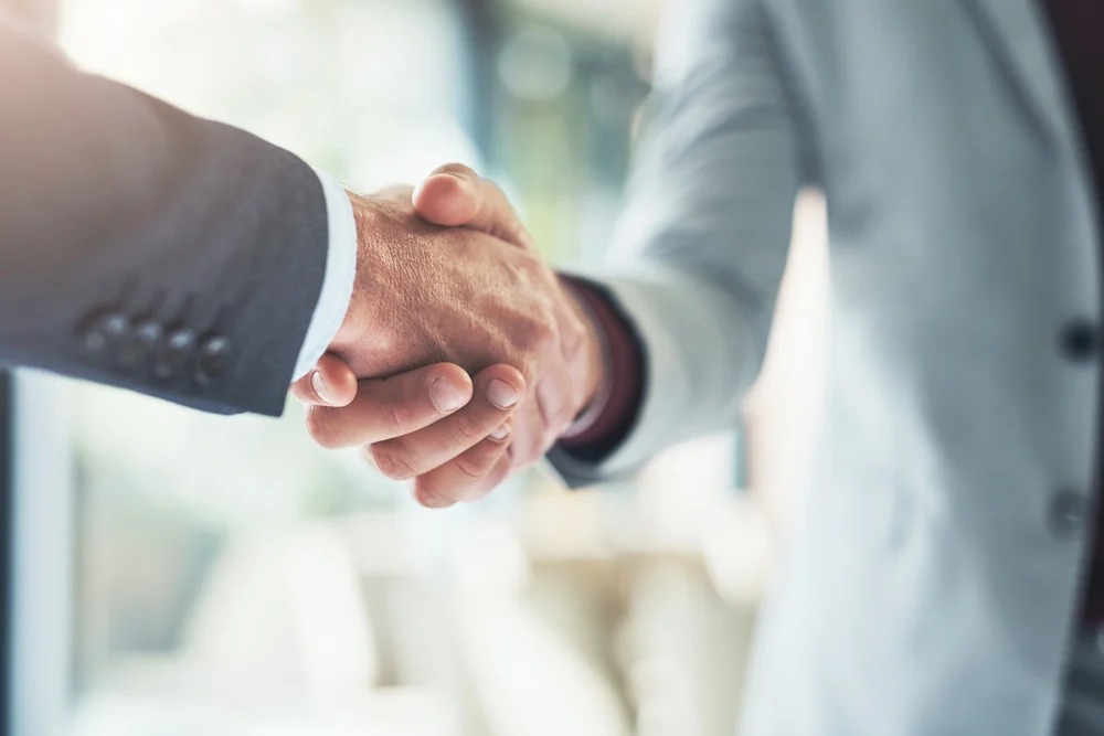Merging for success. two unrecognizable businessmen shaking hands after making a deal in the office.